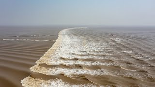 Footage Tidal bore of Qiantang River washes away dozens of spectators [upl. by Kendrah747]