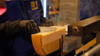 Melting cheese wheel used to make traditional Cheese Raclette at a Christmas market stall in Vienna [upl. by Aniaj935]