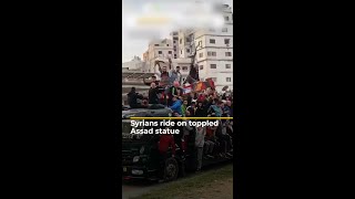 Syrians ride on toppled Assad statue  AJ shorts [upl. by Januisz]