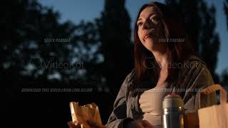 Tranquil scene of Caucasian woman enjoying warm summer evening in the park with tea and fries [upl. by Mixam]