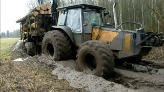 Valtra forestry tractor with big fully loaded trailer in wet forest [upl. by Anirrak]