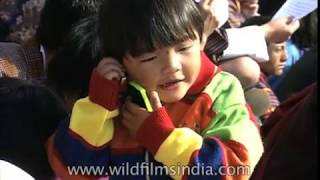 Little Bhutanese girl plays with her toy phone while sitting in the stadium [upl. by Enelec]