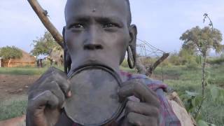 Mursi woman inserts giant lip plate  Omo Valley Southern Ethiopia [upl. by Aneel82]